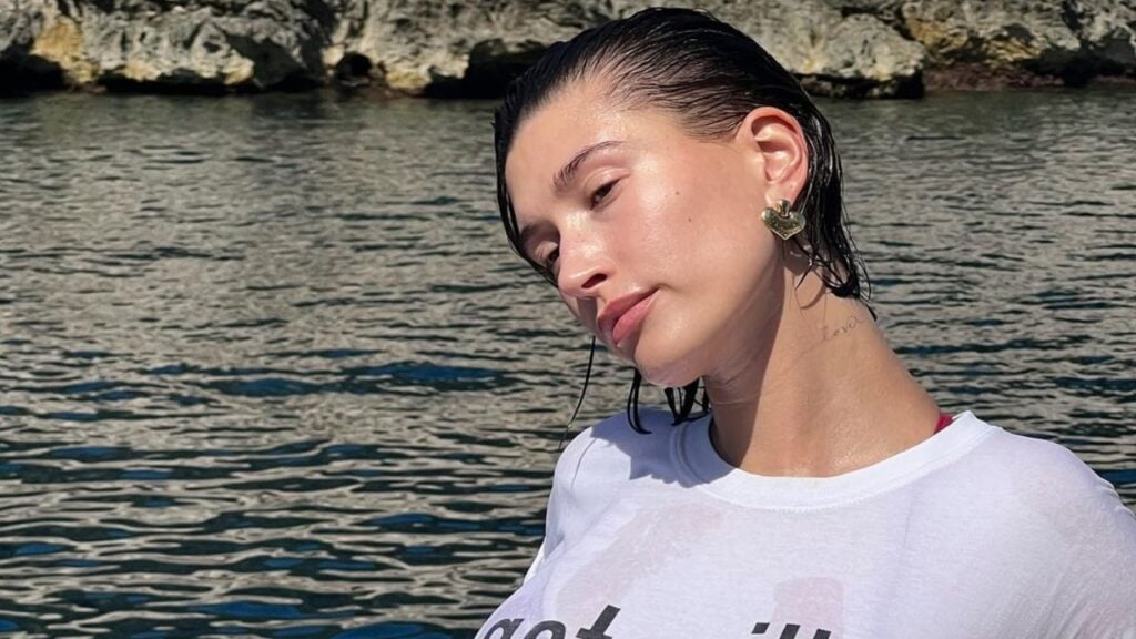 Hailey Bieber in crop top surrounded by vast ocean