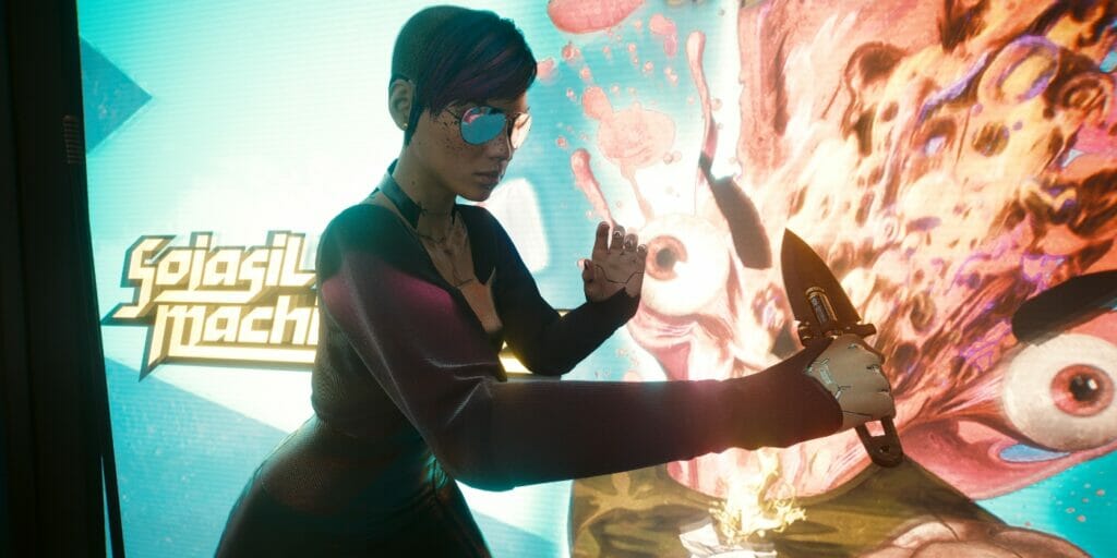 V poses with a throwing knife in front of an advertisement in Cyberpunk 2077