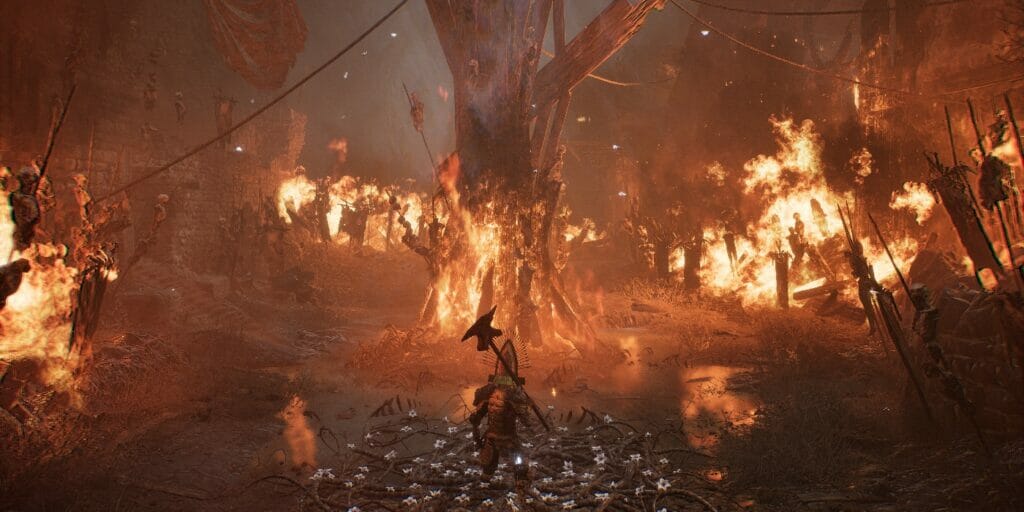 The Lampbearer stands in a burning village in Lords of the Fallen