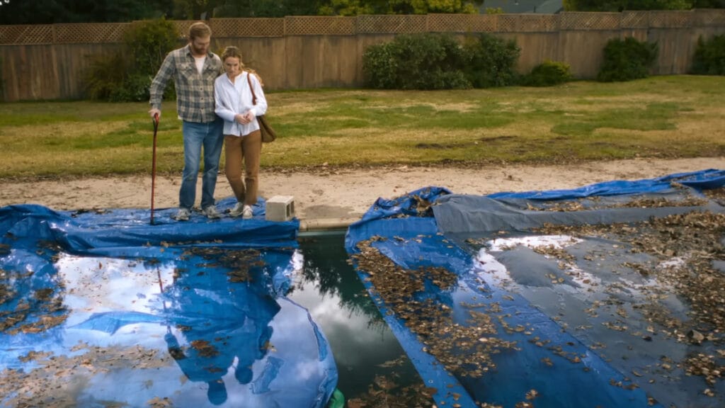 Eve and Ray Waller standing over their new haunted pool in Night Swim.