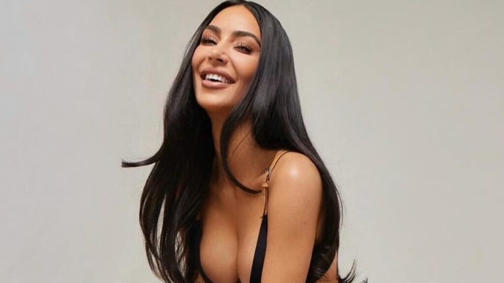 Kim Kardashian posing in black bikini top and skirt.