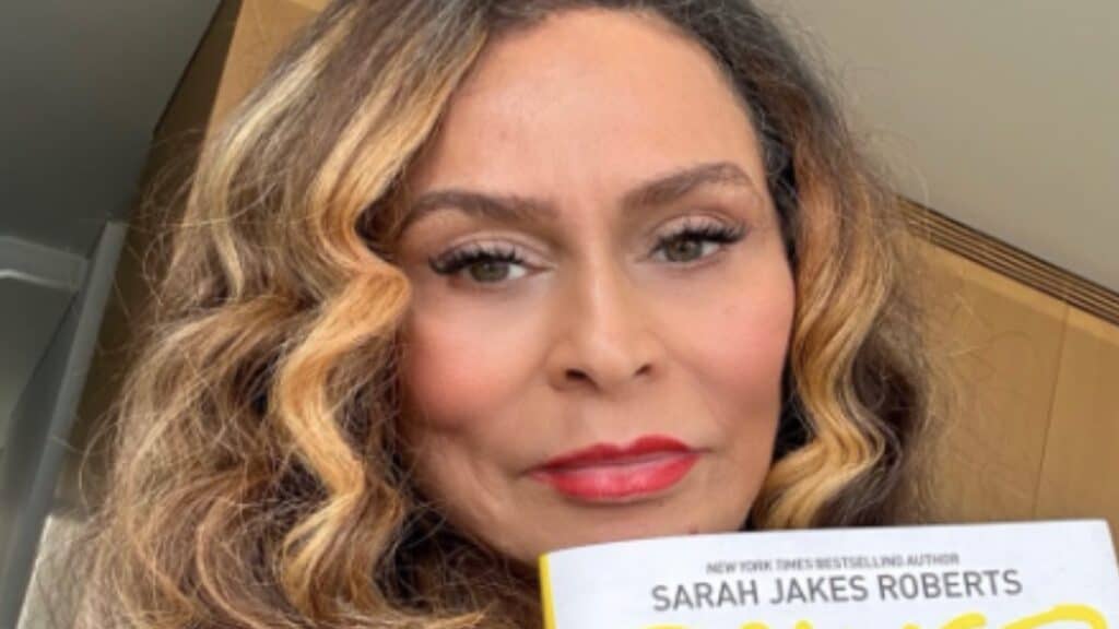 Tina Knowles poses with a book on Instagram