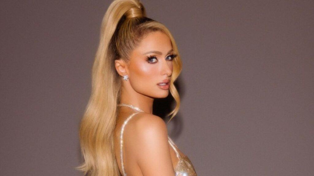 Singer, socialite and anti-Child abuse advocate Paris Hilton in a gold dress and ponytail