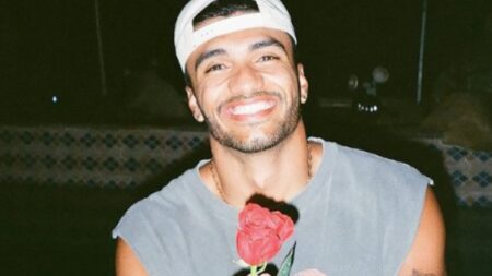 Bachelorette contestant Jonathon Johnson poses with a red rose