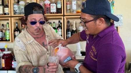 Johnny Depp pours a drink with local bartender in The Bahamas