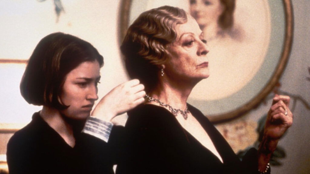 Someone helps Maggie Smith put on a necklace in Gosford Park