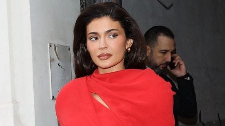 Kylie Jenner sports a red dress and dark hair.