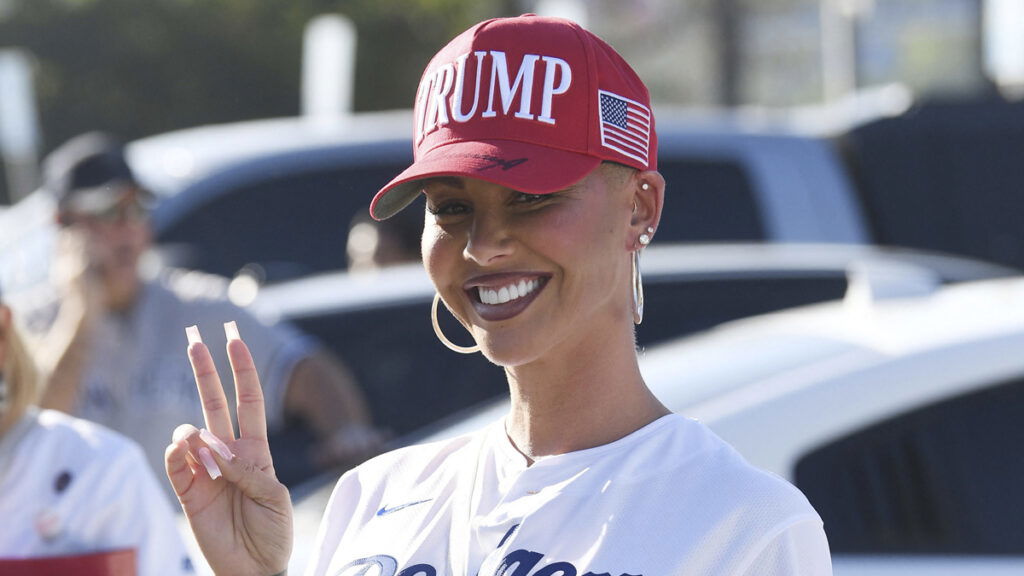 Amber Rose throws a peace sign at the World Series Dodgers game vs the Yankees while sporting her MAGA hat