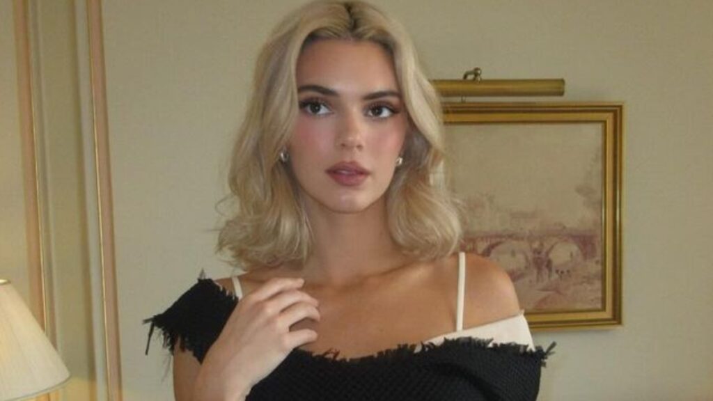 Kendall Jenner wearing a black dress in hotel room ahead of the Paris Fashion Week The Row SS25 show.