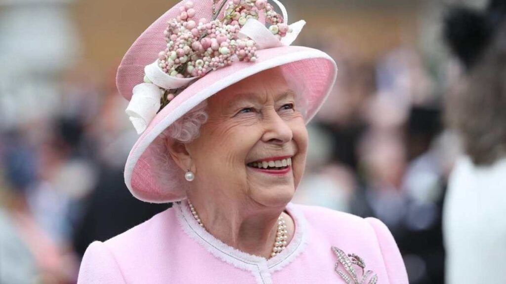 The late Queen Elizabeth II wearing a pink outfit.