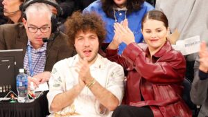 Selena Gomez and Benny Blanco share a moment as they sit on celebrity row during the first quarter of the Philadelphia 76ers vs. New York Knicks game at Madison Square Garden. 22 Apr 2024