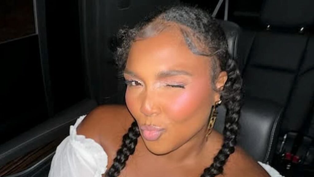 Lizzo posing in a car.