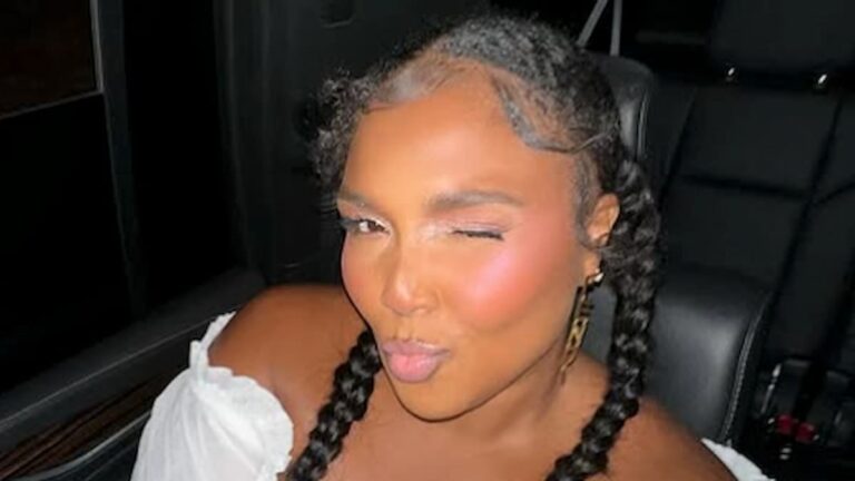 Lizzo posing in a car.