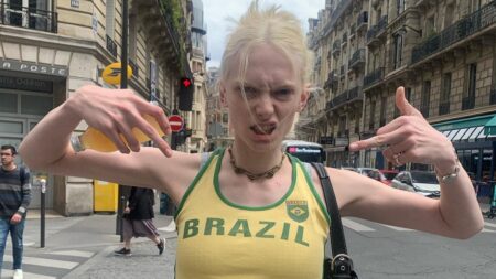 Alex Consani posing in a yeloow tank top in the middle of the street