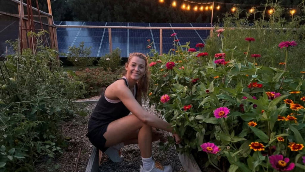 Blake Lively in a black tank-top and shorts tending to her flower garden.