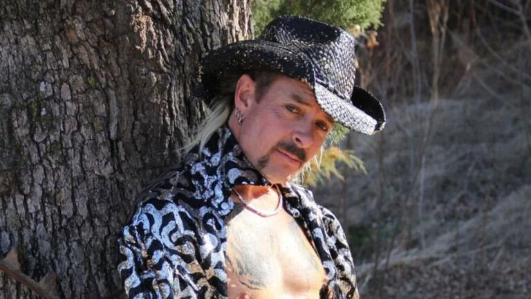 Joe Exotic posing by a tree