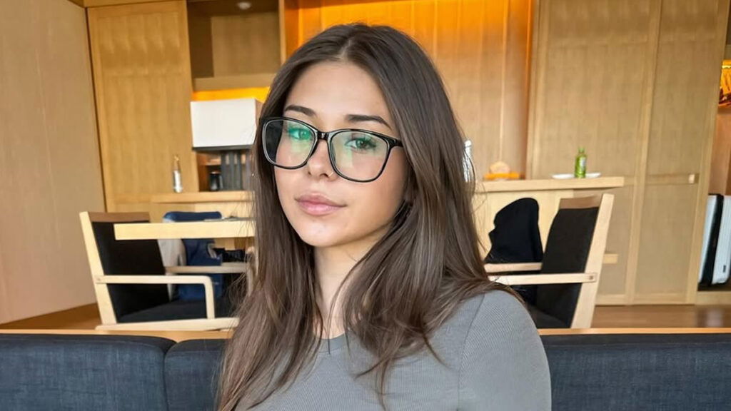 Sophie Rain poses wearing eye glasses in a living room