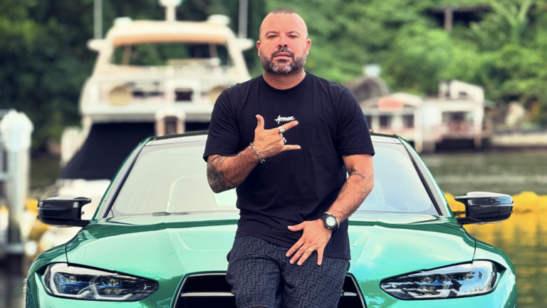 Brazilian Influencer RICARDO GODOI standing in front a car