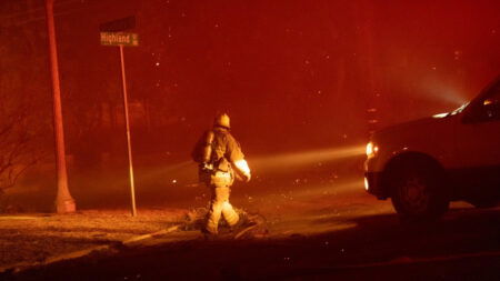 A Californian firefighter waalks down the street