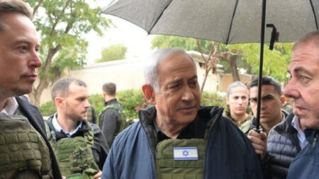 Elon Musk stands beside Israeli leader Netanyahu while wearing a bulletproof vest