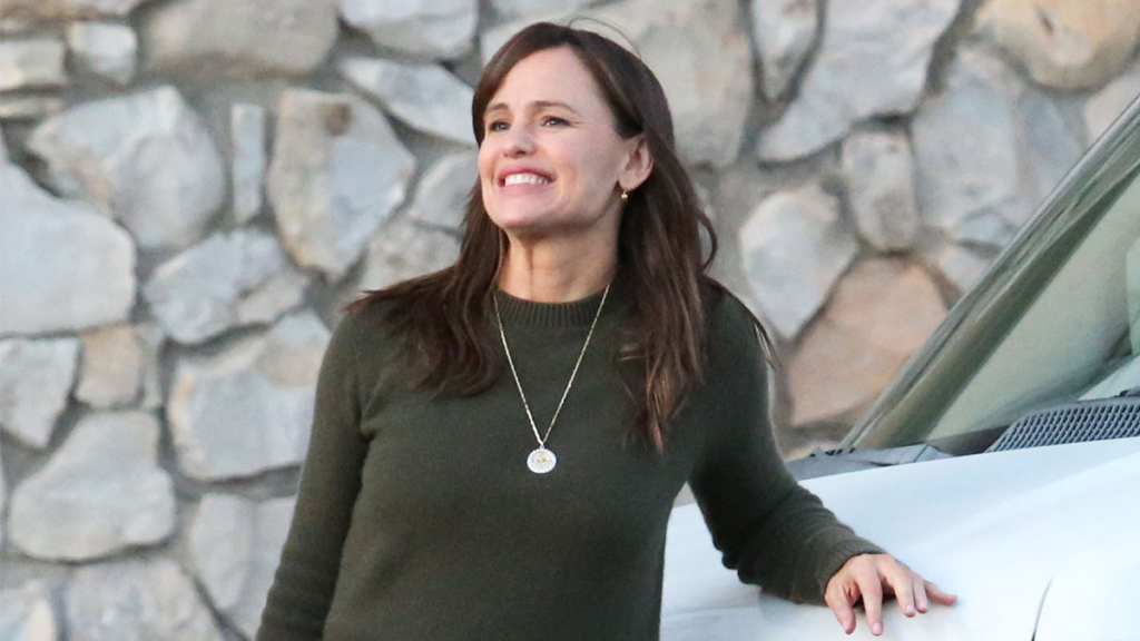 Jennifer Garner smiling while leaning on a van