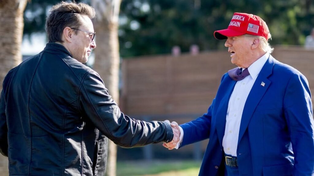 Donald Trump and Elon Musk share handshake.