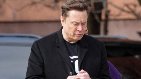 Elon Musk wearing a black coat.