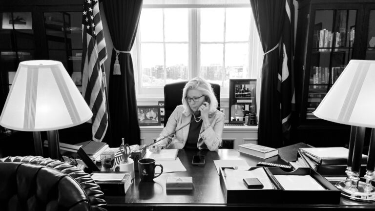 A black and white picture of Liz Cheny on the phone in her office