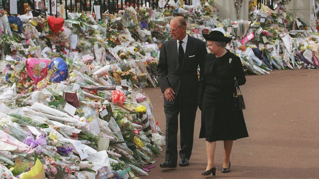 Queen Elizabeth and Prince Philip walk past millions of tribute items to Princess Diana after her death. 