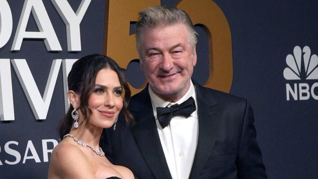 Hilaria Baldwin and Alec Baldwin pose on the red carpet of SNL 50