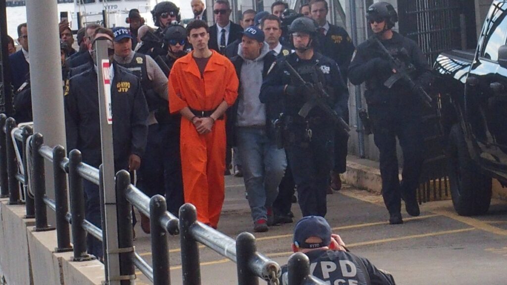 Luigi Mangione escorted by cops outside NYC court.