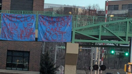 A blue sign with an inspiring message hangs outside UW hospital