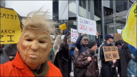 A person in a Trump mask poses with fellow protestors at a Tesla protest in NYC