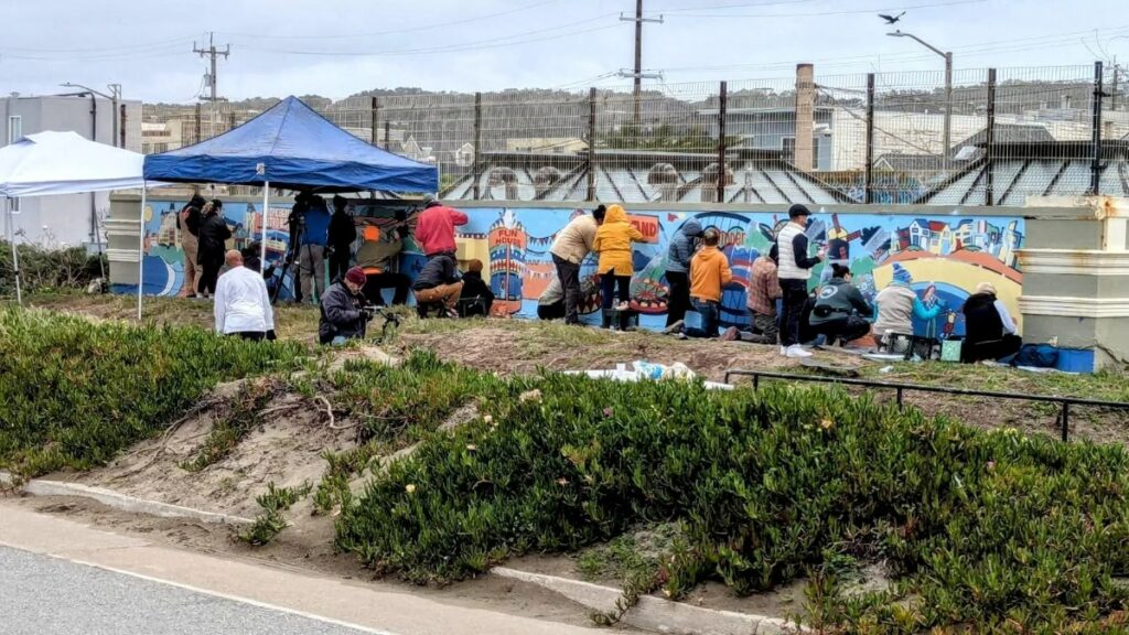 Community residents work to restore a defaced mural in San Francisco