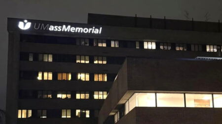 A night time shot of the UMassMemorial sign in Worcester with the first two lights out