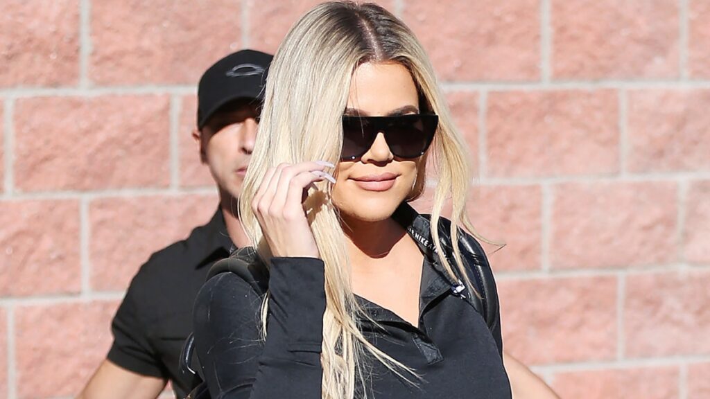 Khloe Kardashian rocks dark sunglasses.