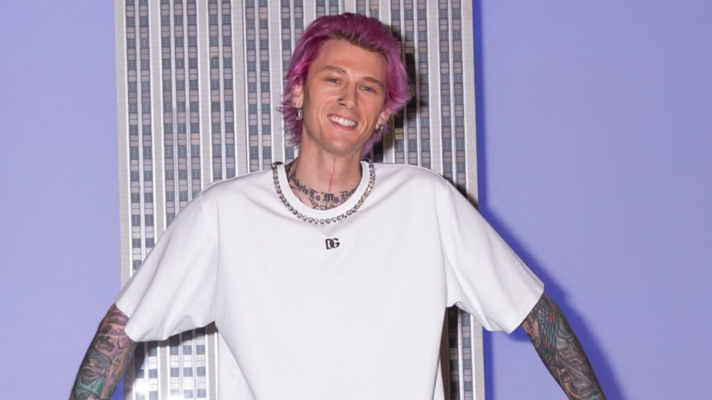 Machine Gun Kelly smiles at event.