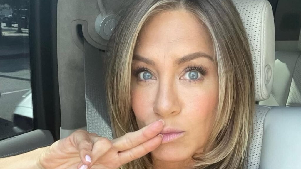 Jennifer Aniston poses for a selfie in her car.