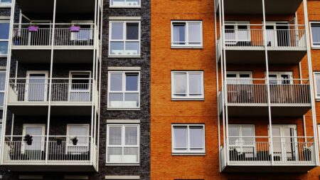a building with several floors of apartments, painted gray and orange