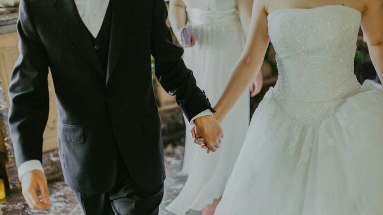 a man and woman holding hands, at a wedding