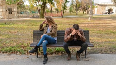 A couple sitting on a bench after a fight