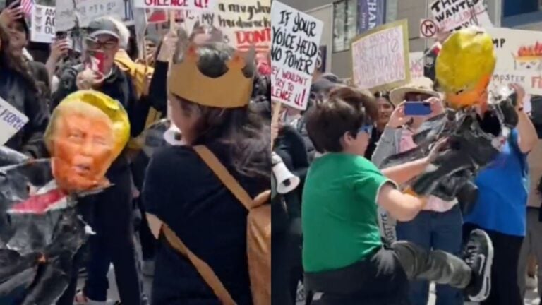 A pinata of Trump getting hit by protestors at a Chicago protest