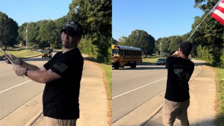 Virginia man waves flag outside local school.